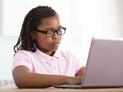 Girl doing homework at computer.