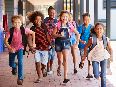 A diverse group of young students runs towards the viewer.