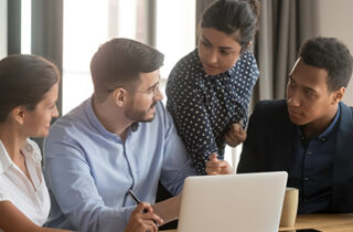 4 adults working on the computer