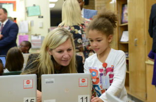 A student and teacher working on a laptop