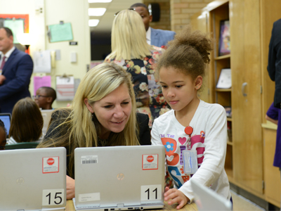 A student and teacher working on a laptop
