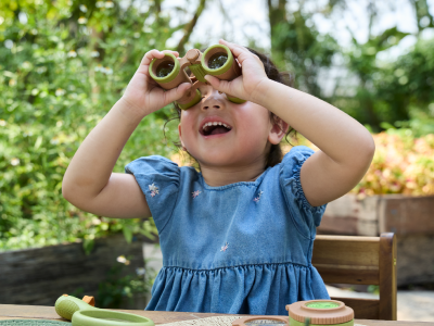 A toddler looking through binoculars